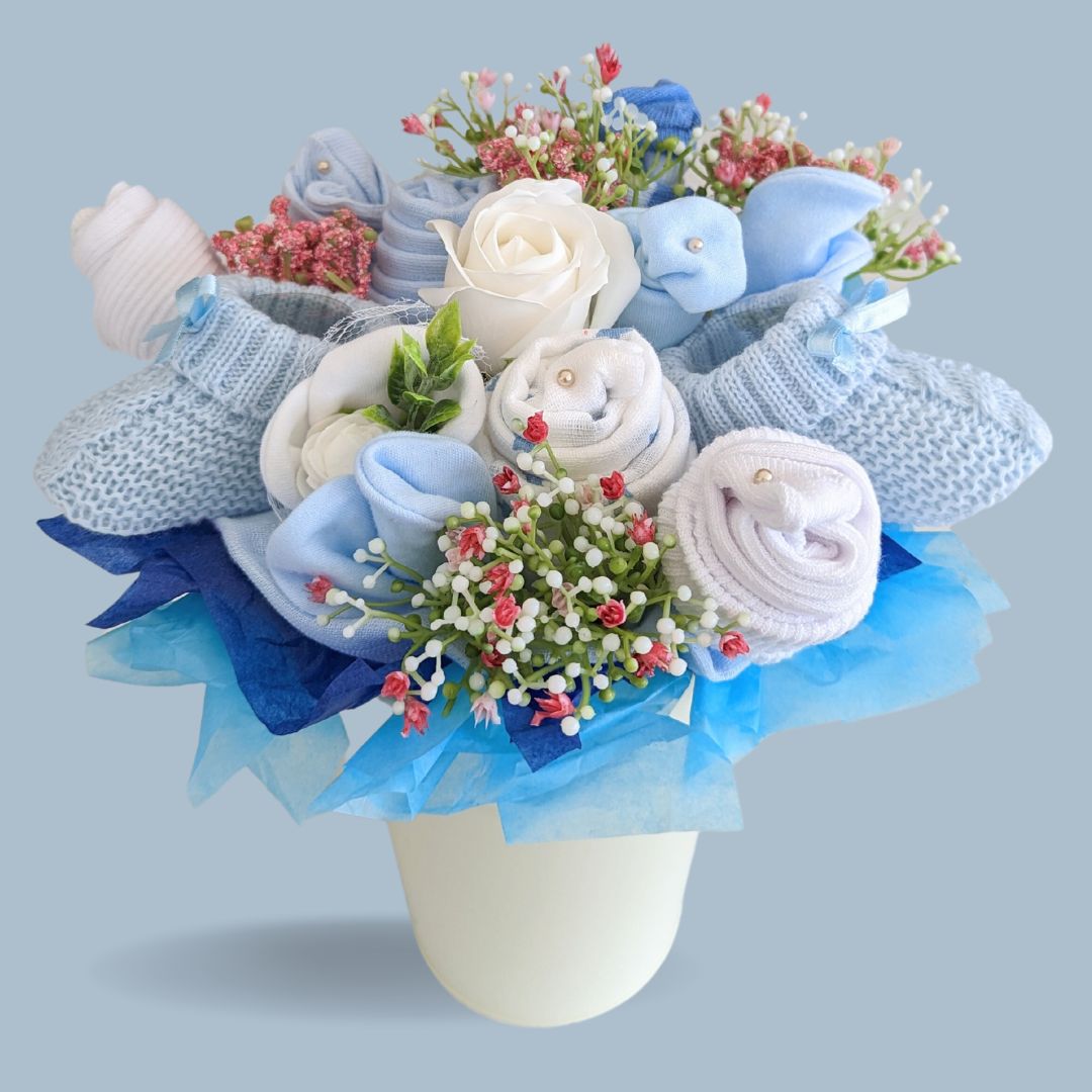 New mum gifts bouquet. With blue flowers made of rolled up muslins, socks, mittens and hat.