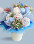 New mum gifts bouquet. With blue flowers made of rolled up muslins, socks, mittens and hat.