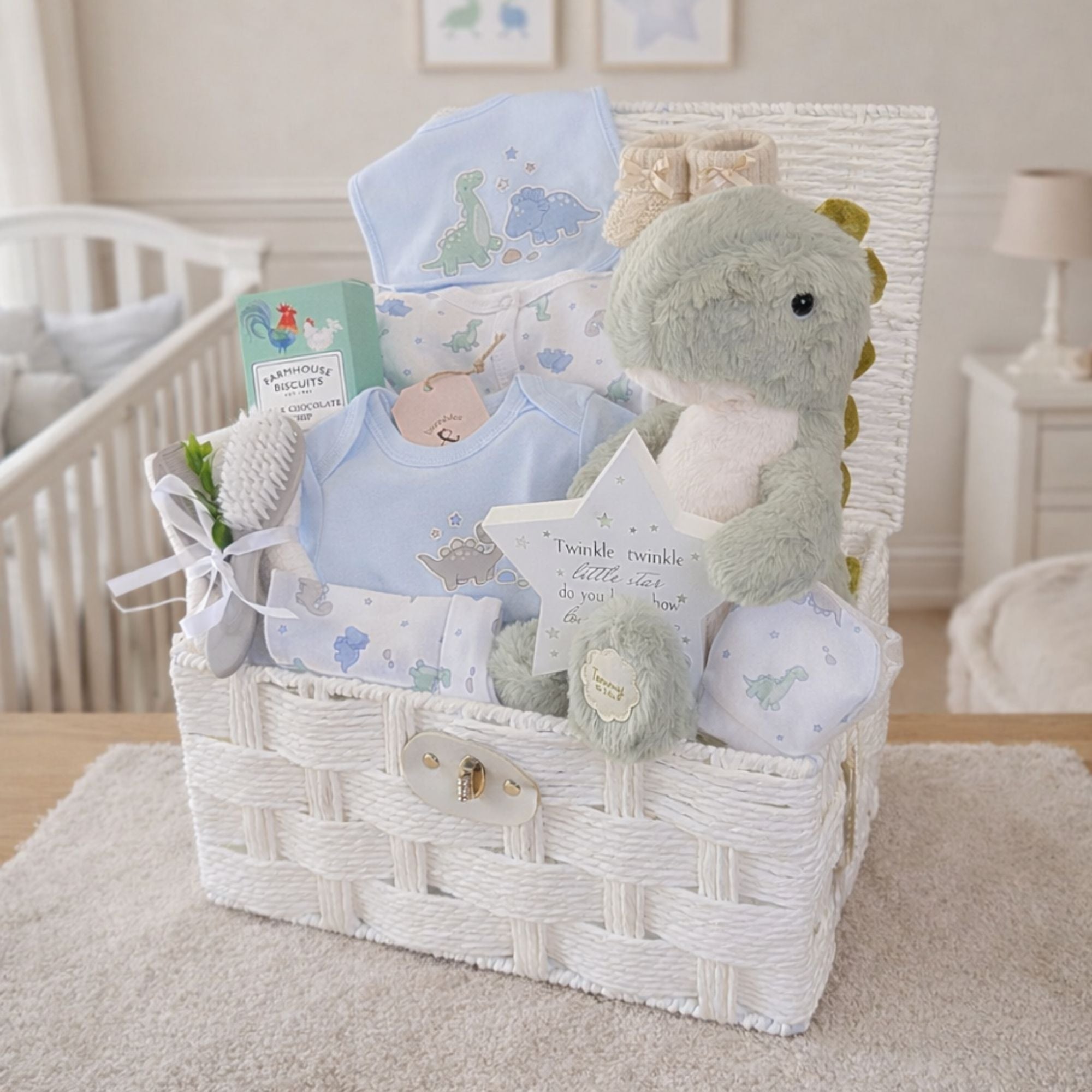 Gift hamper for a new mum and baby boy. Includes blue clothes, soft dinosaur toy and biscuits for mummy.