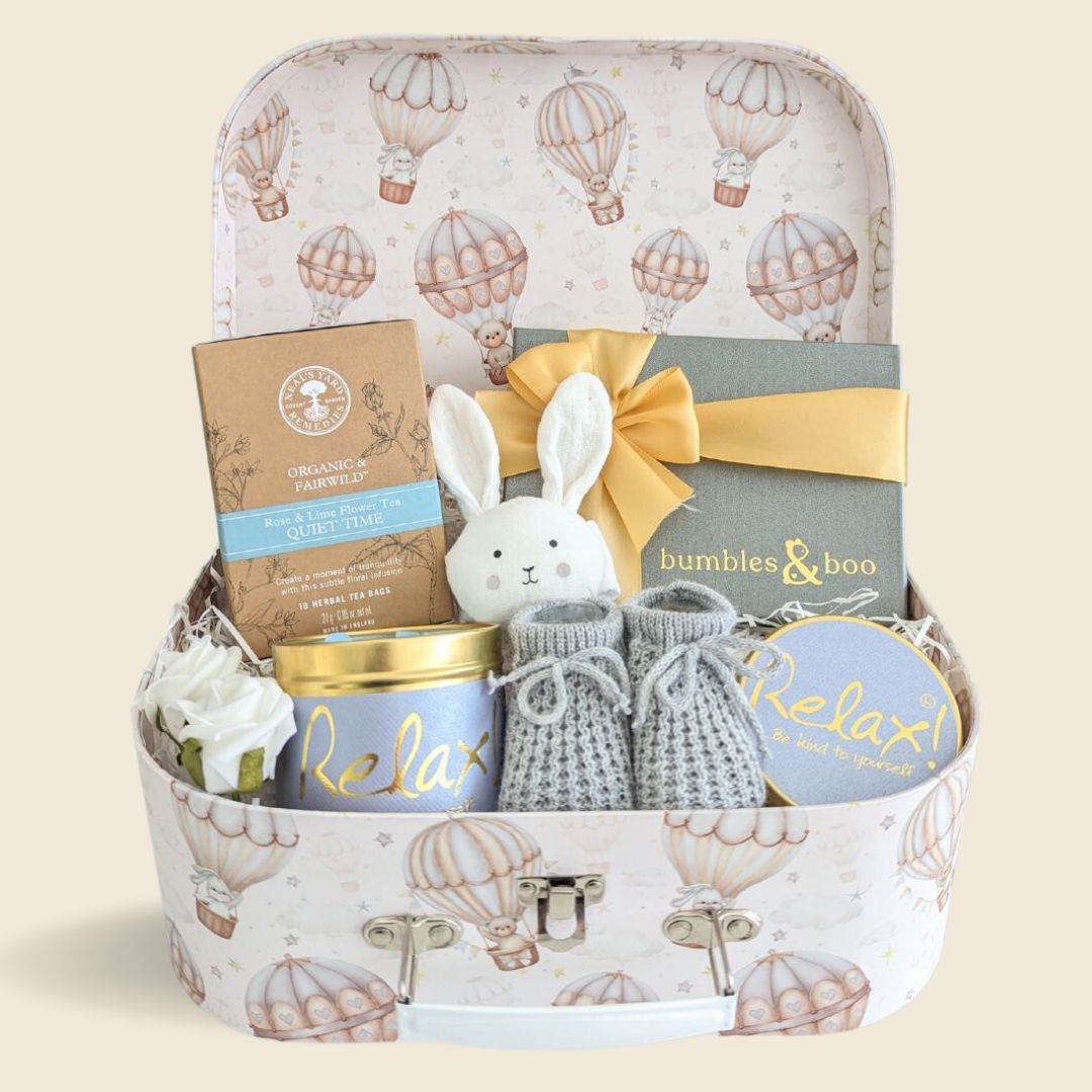Stunning new mum gifts hamper with delicious chocolates, organic tea, relaxation candle and adorable gifts for baby. Presented in a luxury luggage trunk hamper.