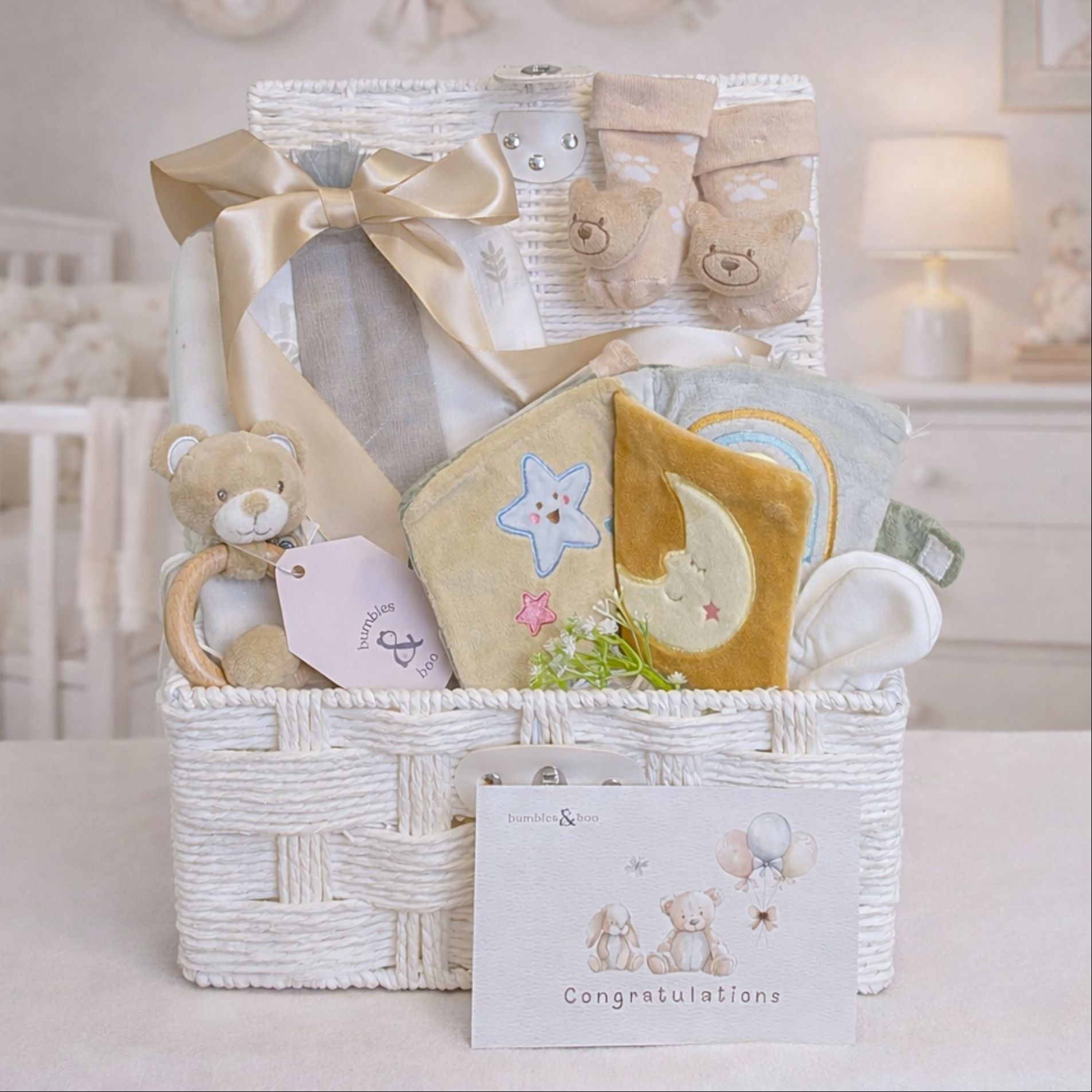 Newborn baby gifts in a hamper basket. Presents include soft book and a unisex beige theme.
