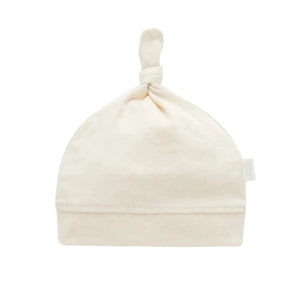 Organic cotton baby knot hat with adjustable top knot and ribbed band, soft newborn baby clothes hat in natural cream fabric.