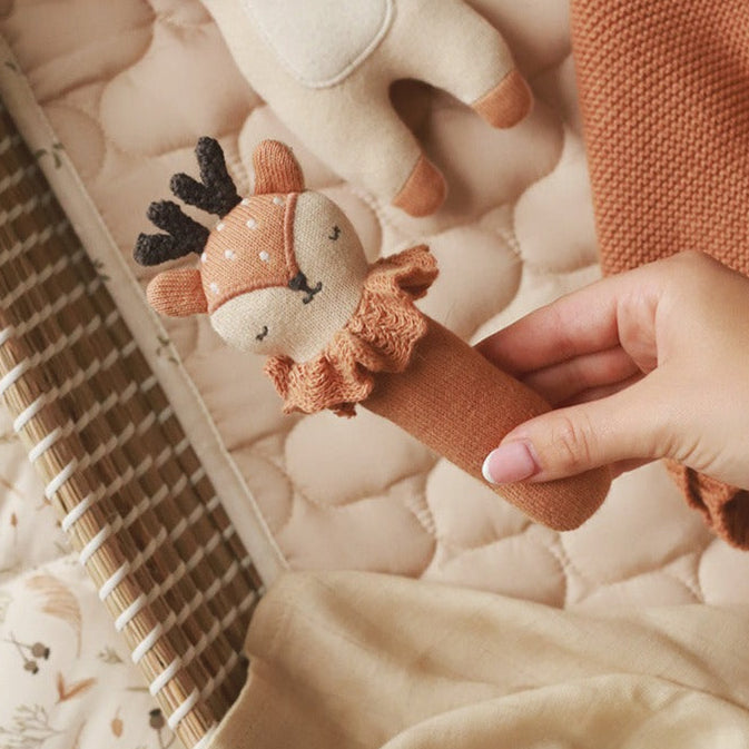 Organic baby rattle with a deer face, this stick rattle is a burnt orange colour