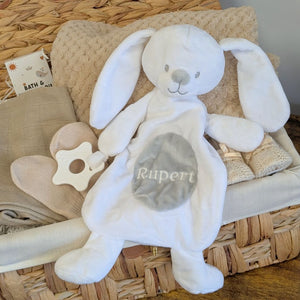 Personalised baby comforter in a white plush bunny toy style with a custom name across the tummy and teething rings attached