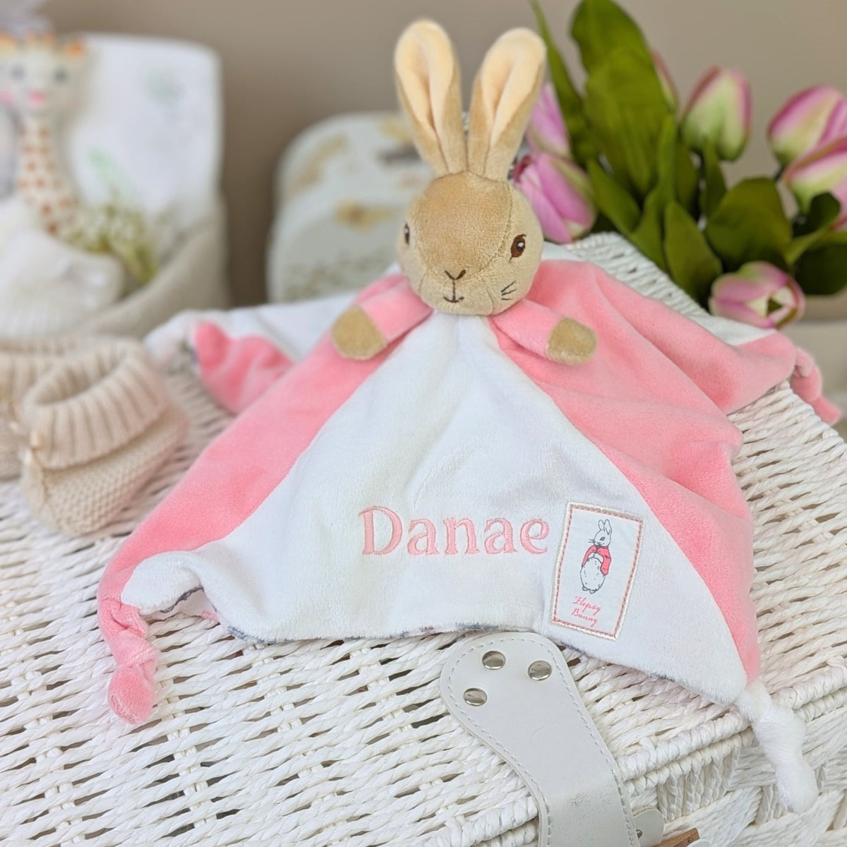 Personalised baby comforter in pink and white with attached flopsy bunny toy. Embroidered with the name Danae