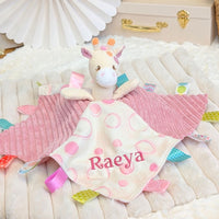 Personalised baby comforter, pink with sensory ribbons and attached giraffe toy embroidered with the name Raeya