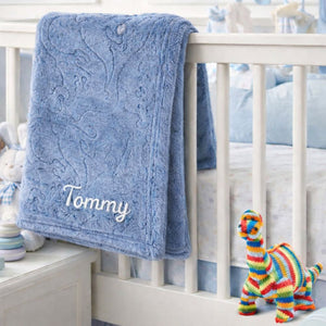 A personalised dark blue baby blanket with an embossed dinosaur theme.