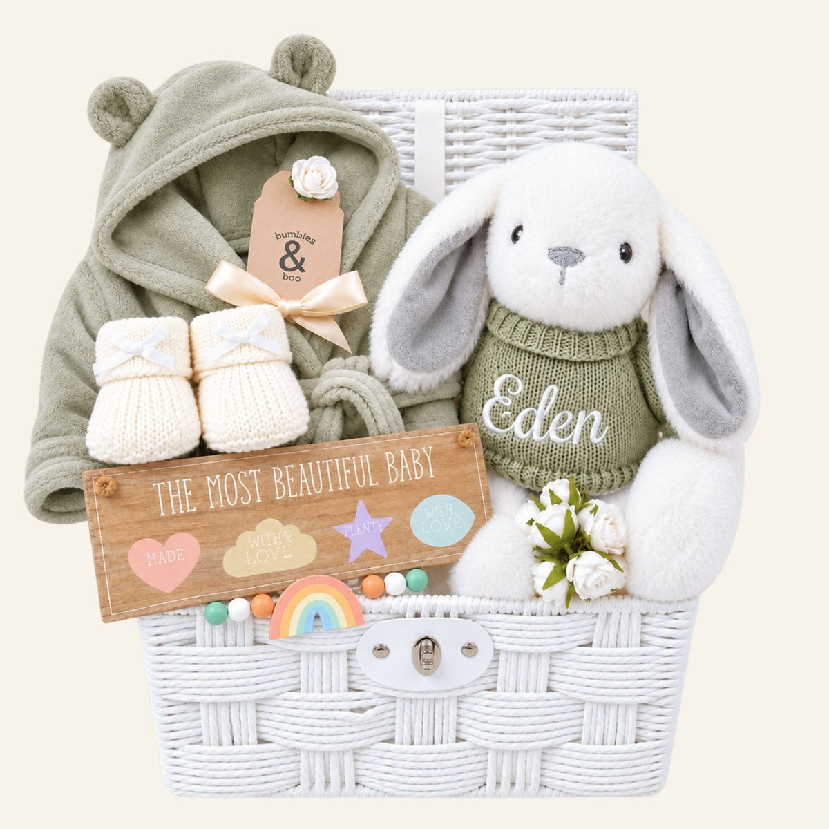 White new baby gifts hamper full of new baby gifts including bunny, booties and baby dressing gown.
