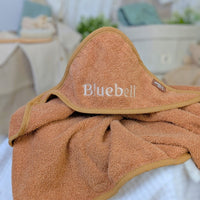 Personalised hooded bath towel for a baby in caramel colour.