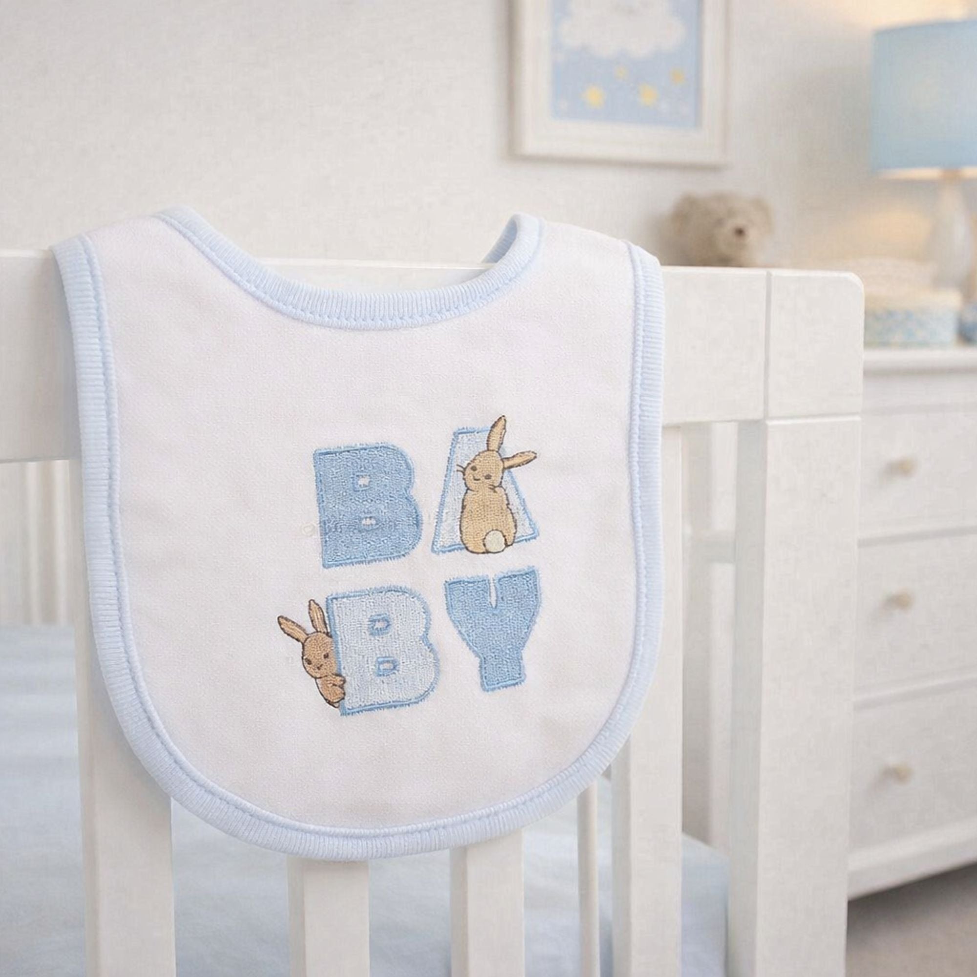 Peter rabbit baby clothing set in blue and white with 'baby' embroidered on the bib with a bunny rabbit.