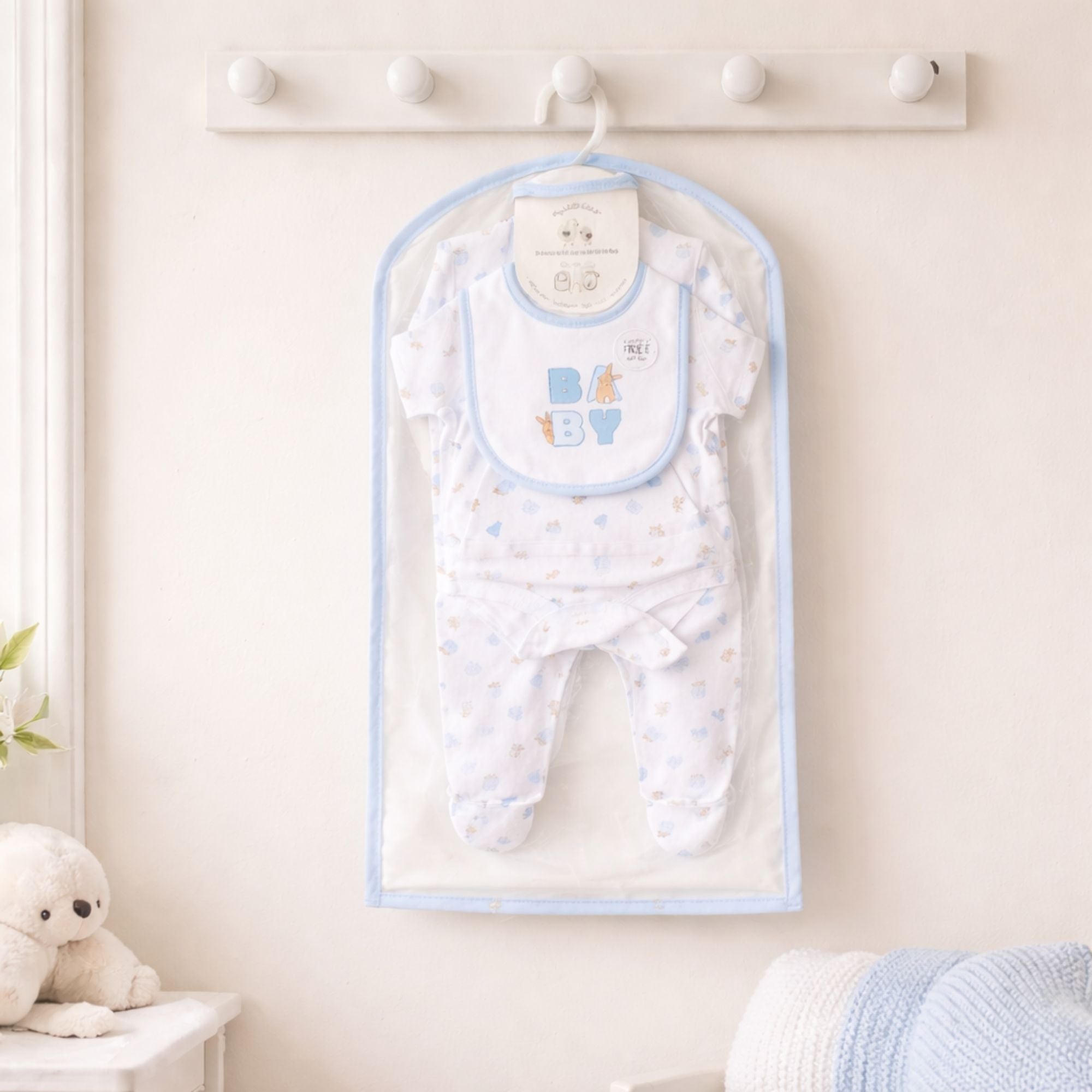 Peter rabbit new baby clothing set in white and blue with a bunny motif on the bib and bunny rabbits on the clothing.