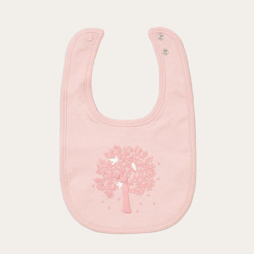 Pink baby bib with tree design.