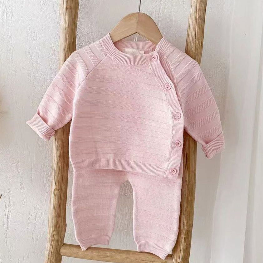 Pink baby girl clothing set in striped knitted baby clothes design with button fastening top and matching trousers.