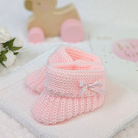 Pink plain knit baby booties with side bow suitable for 0-6 months. 