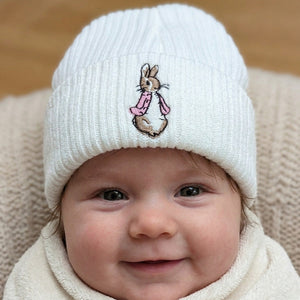 White knitted baby hat with pinkembroidered bunny detail close-up