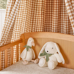Goose and bunny soft toys with matching green bows displayed together