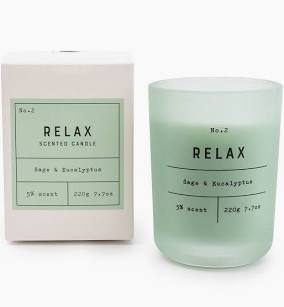 In a light green frosted glass jar a sage and eucalyptus scented candle