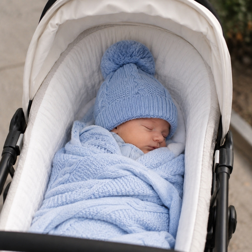 A blue pom pom hat made from knit recycled cotton