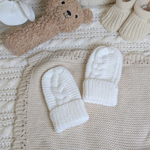 Knitted white baby mittens in white