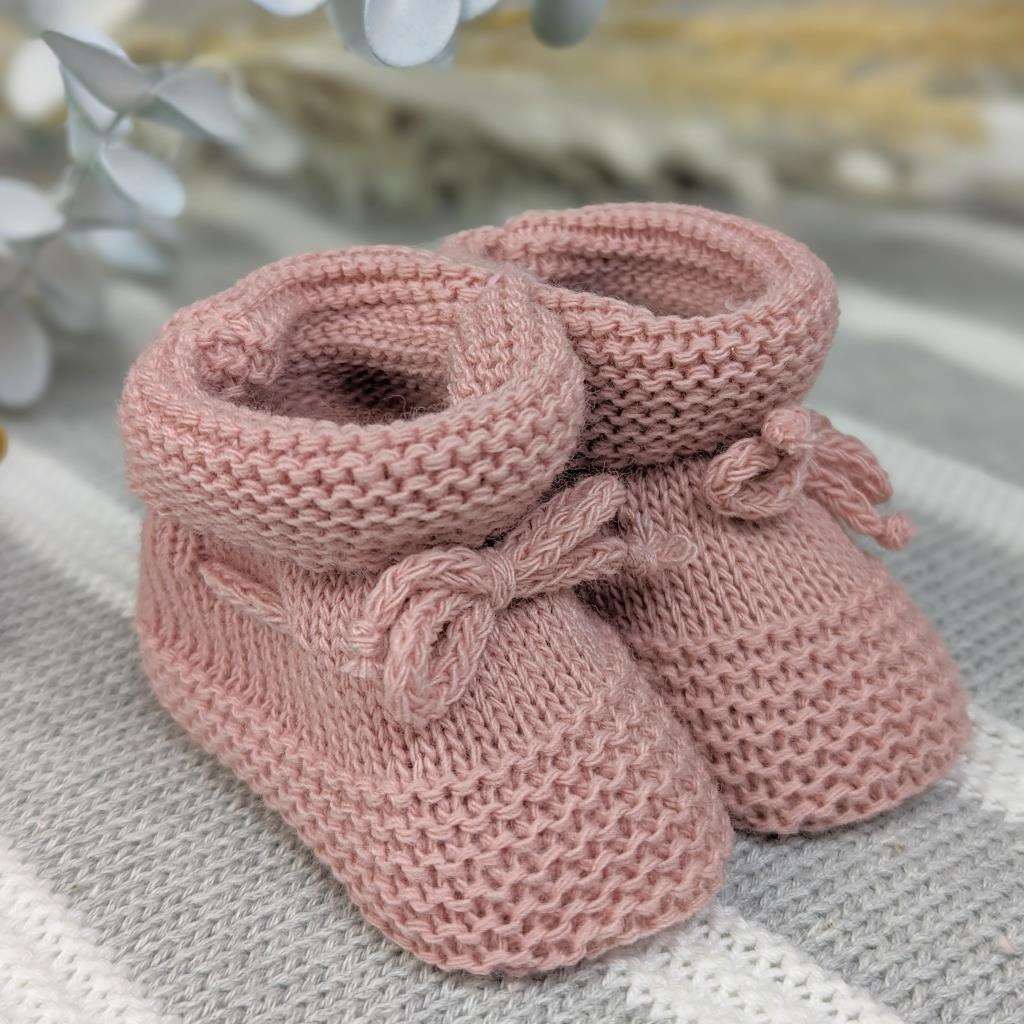 Rose gold baby booties with ties.
