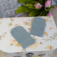 Sage green knit baby mittens.
