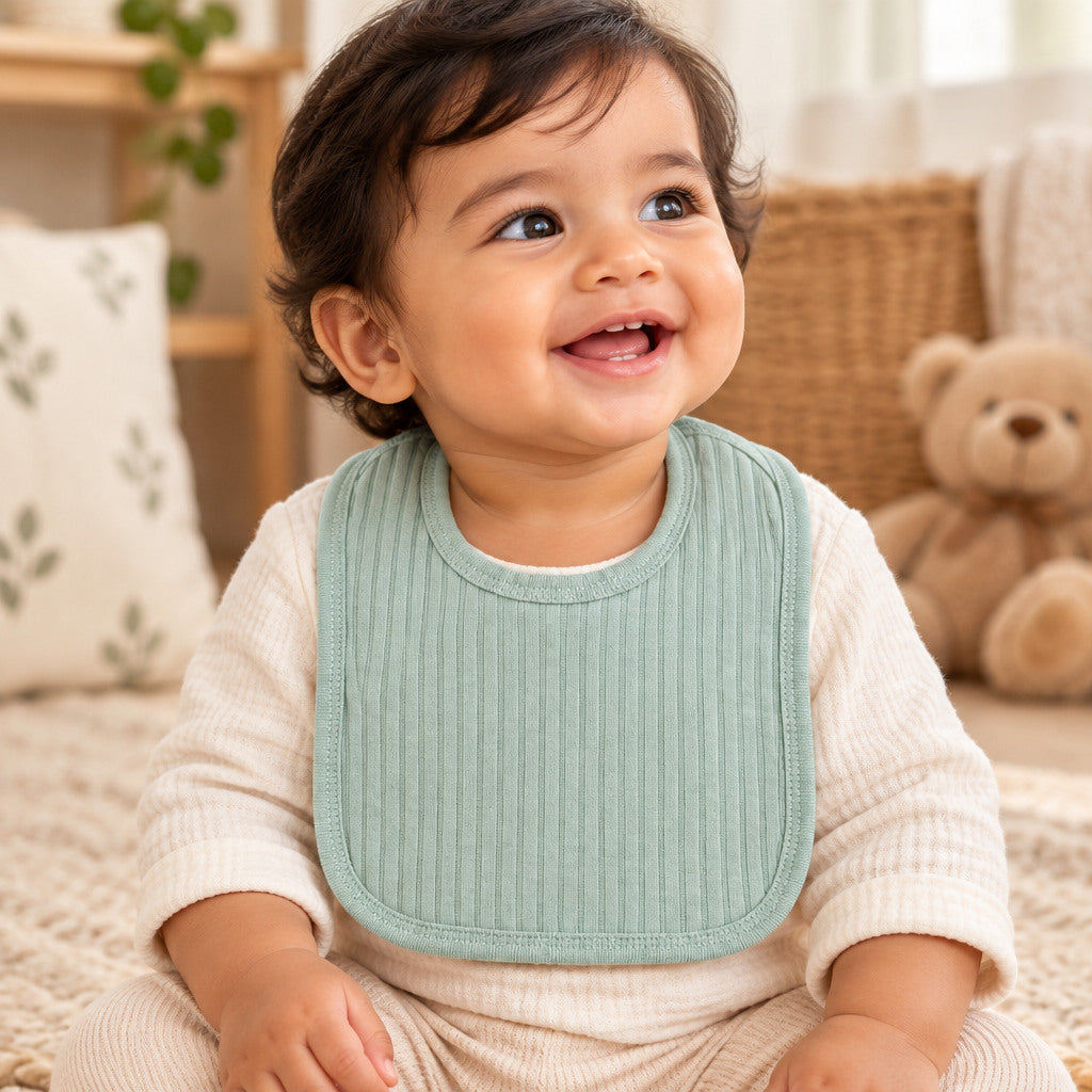 Sage green cotton baby bib with Velcro fastening
