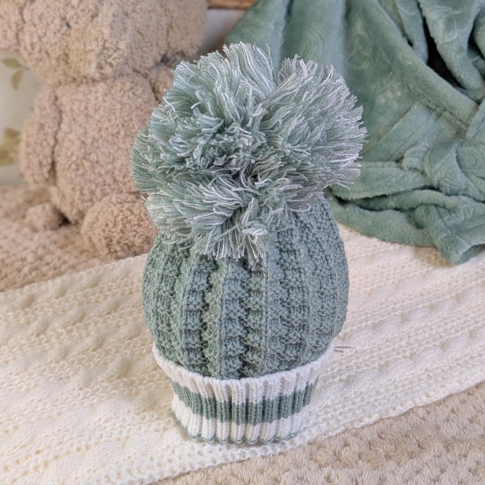 Sage green knitted baby pompom hat.