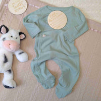 Sage green ribbed baby sleepsuit with poppers and a ribbed design.