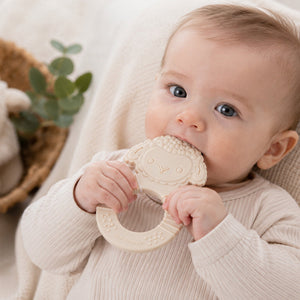Baby teether in the shape of a lamb, with a baby holding the ring shaped grip. Made from food-grade silicone

