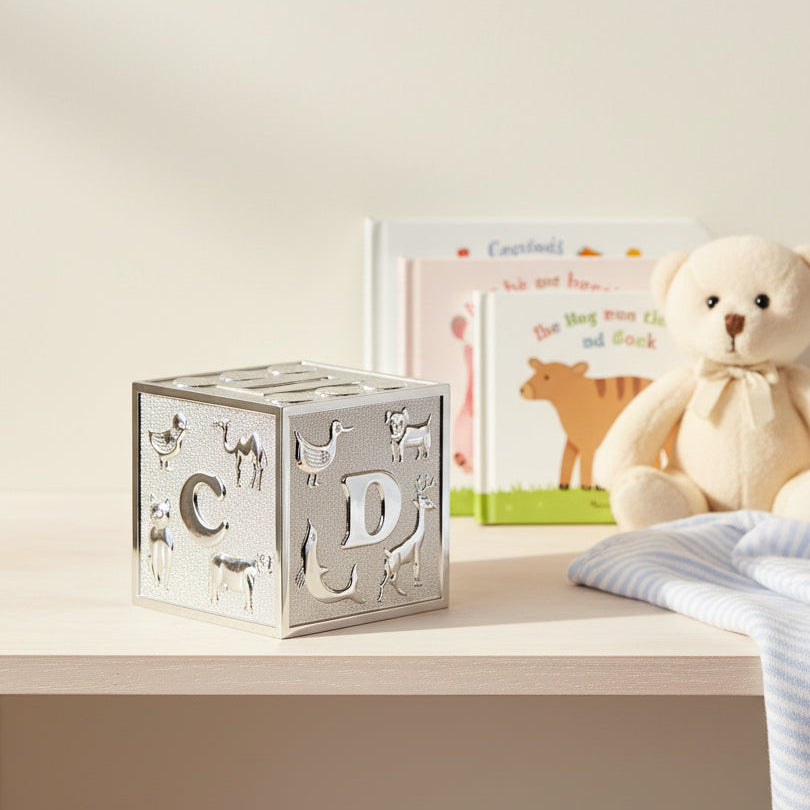 Silver-plated alphabet cube money box with raised letters, animal designs and a coin slot on top