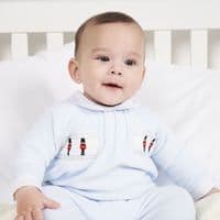 Baby wearing the sky blue velour onesie, showing soldier embroidery and the white Peter Pan collar.
