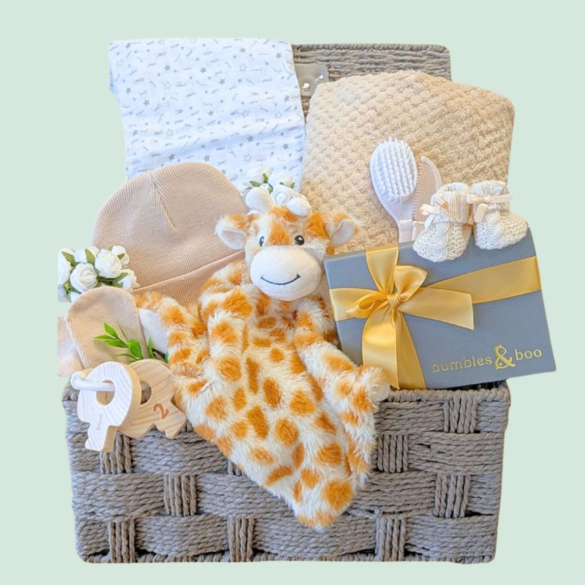 Baby hamper basket with gifts including plush giraffe and chocolates for the new parents.