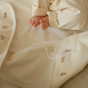 Cream embroidered bunny blanket by Avery Row in lifestyle photo with baby. 