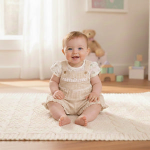 Stone and beige baby girl short dungarees with floral top, soft two piece baby clothes set displayed in nurser