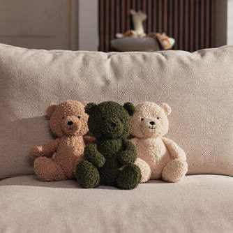 Three brown teddy bears sitting in a row.