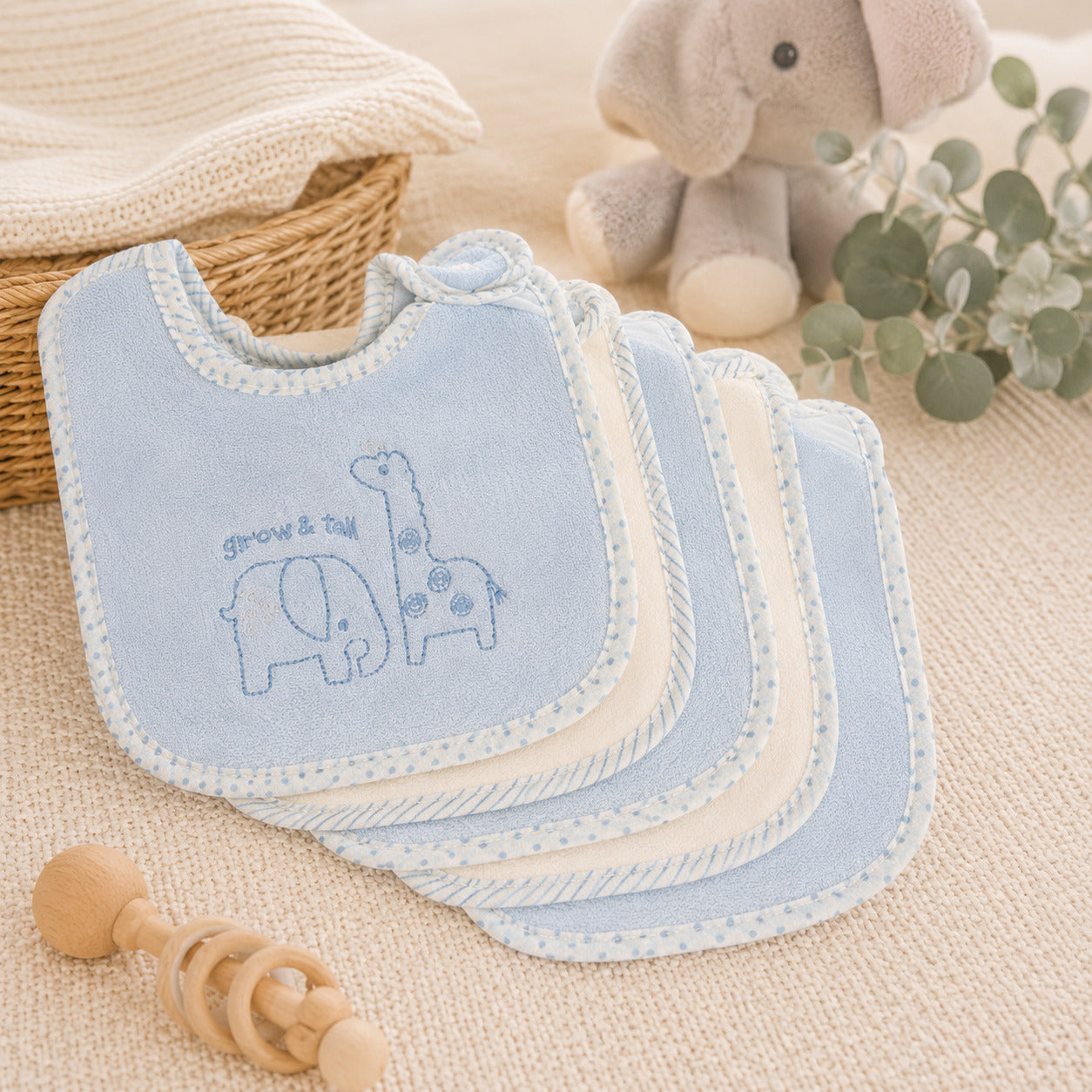 Set of 5 terry cloth baby bibs, 3 in light blue and 2 white with white polka-dot trim and embroidered elephant and giraffe designs