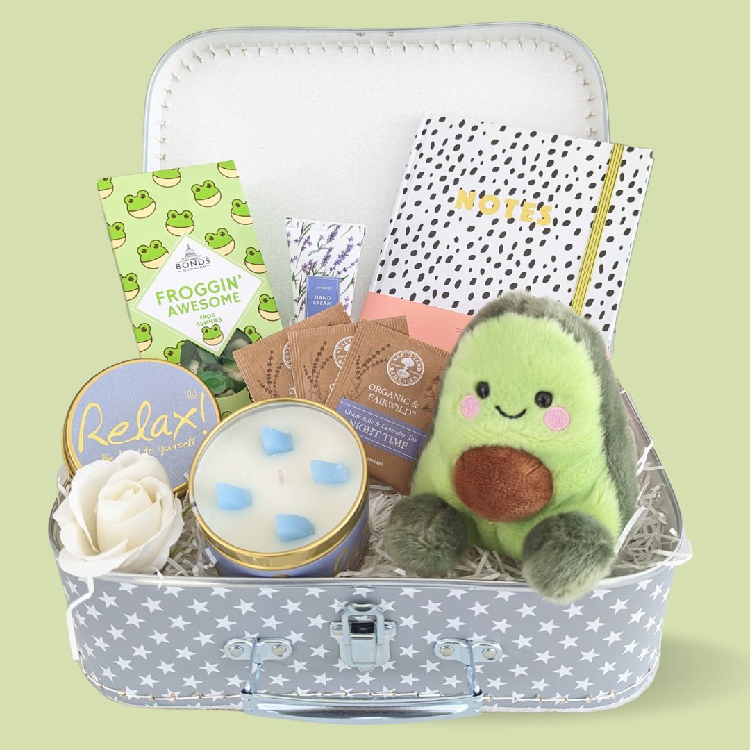 Avacado treat trunk with sweets, candle, tea bags, note book and hand cream. 
