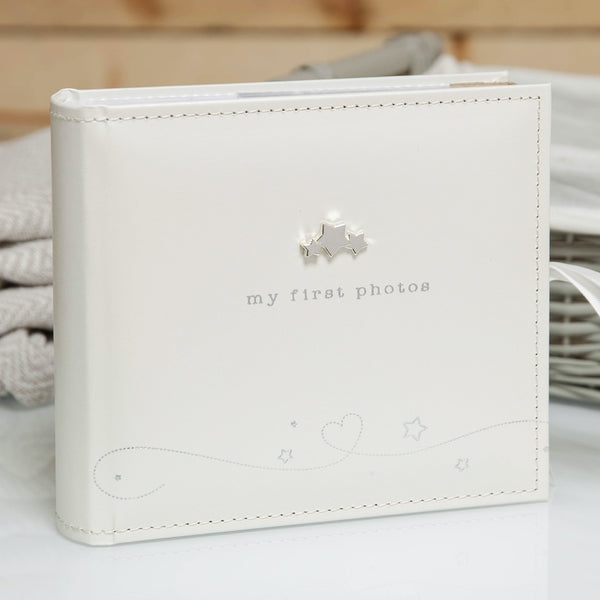 White faux-leather photo album with silver stars and text reading 'my first photos'