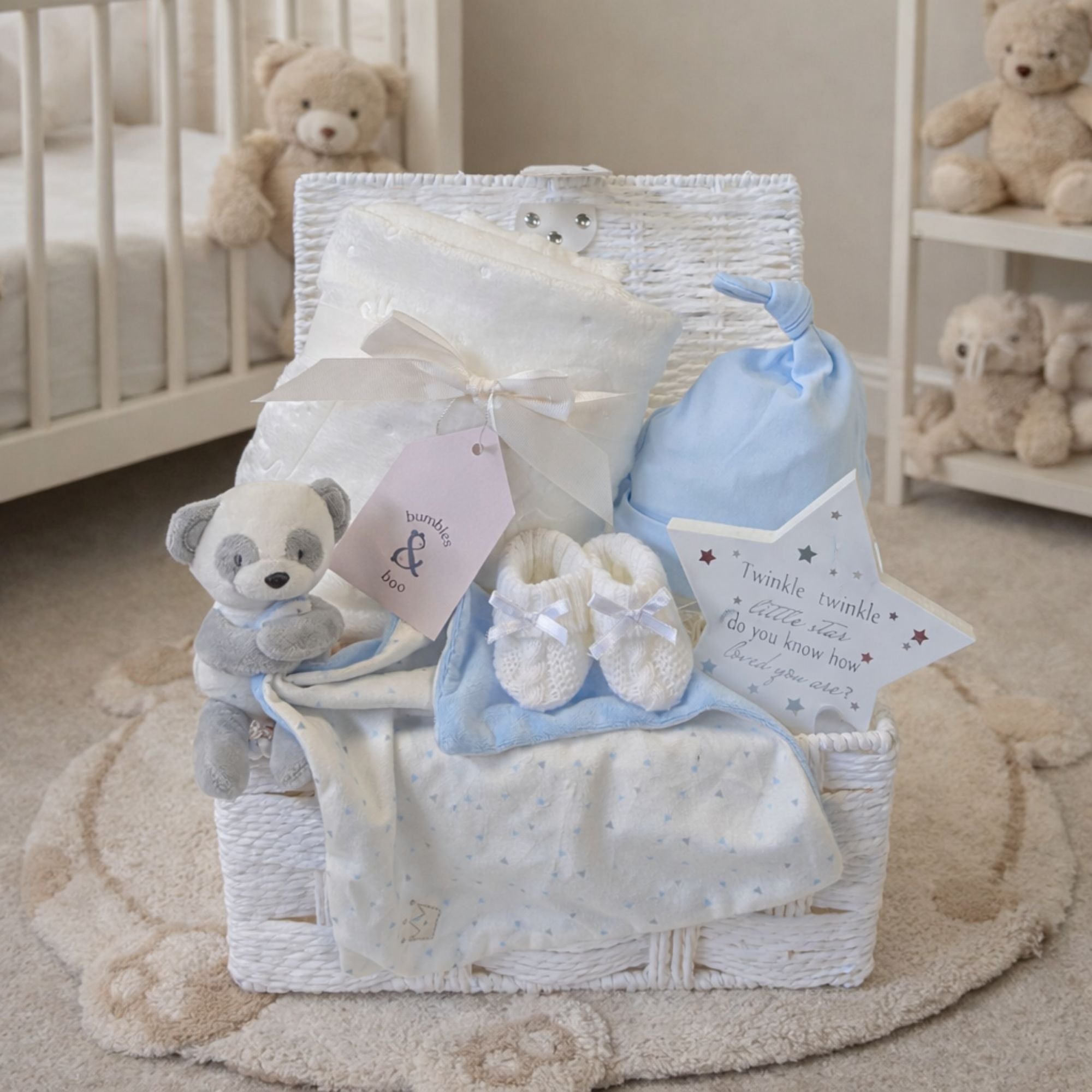 Unique baby boy gifts in a white hamper basket with blanket, blue hat and panda bear newborn comforter.