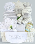 Baby shower hamper basket with zebra soft toy, award winning baby wash, blanket, white baby clothing and baby knit booties.