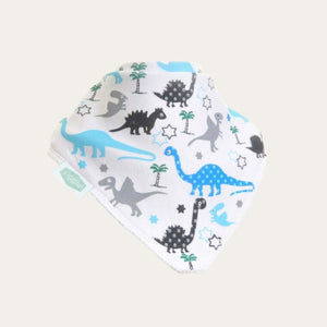 White bandana baby bib with blue, grey and black dinosaurs and small green trees, shown on a pale background.