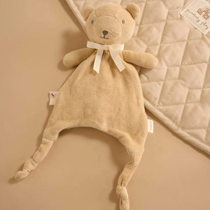 Wheat bear baby comforter laid flat, showing soft velour body, ribbon bow and knotted feet