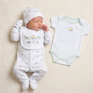 White baby clothes set with a dinosaur print. This 5 piece outfit includes sleepsuit, hat. mittens and bib worn by a baby with the bodysuit shown on the right.