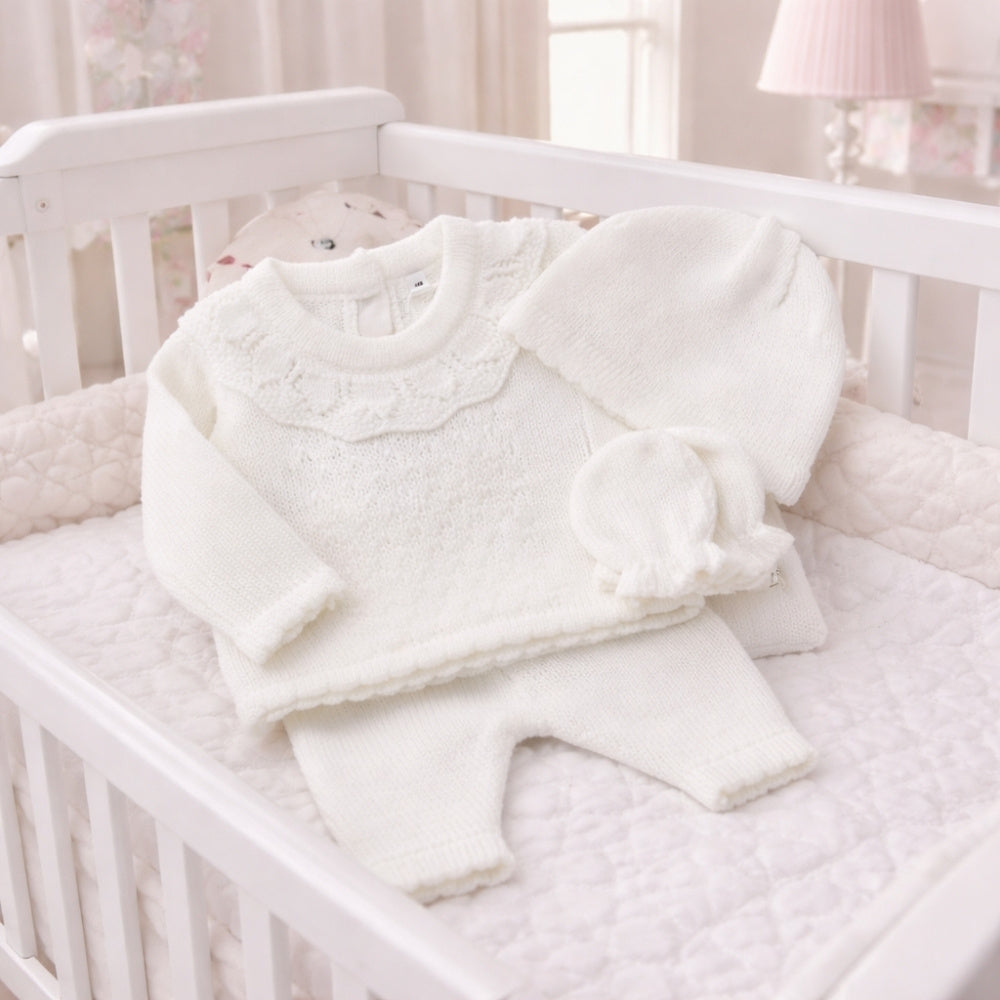 White baby girl knit outfit with a frilly neckline and hat and mittens
