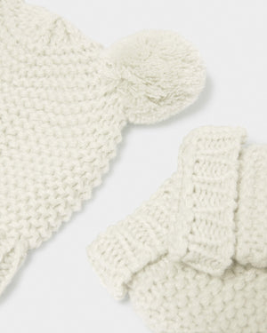 Close-up of the white hat’s pom-pom ear and matching knitted mitten cuff.