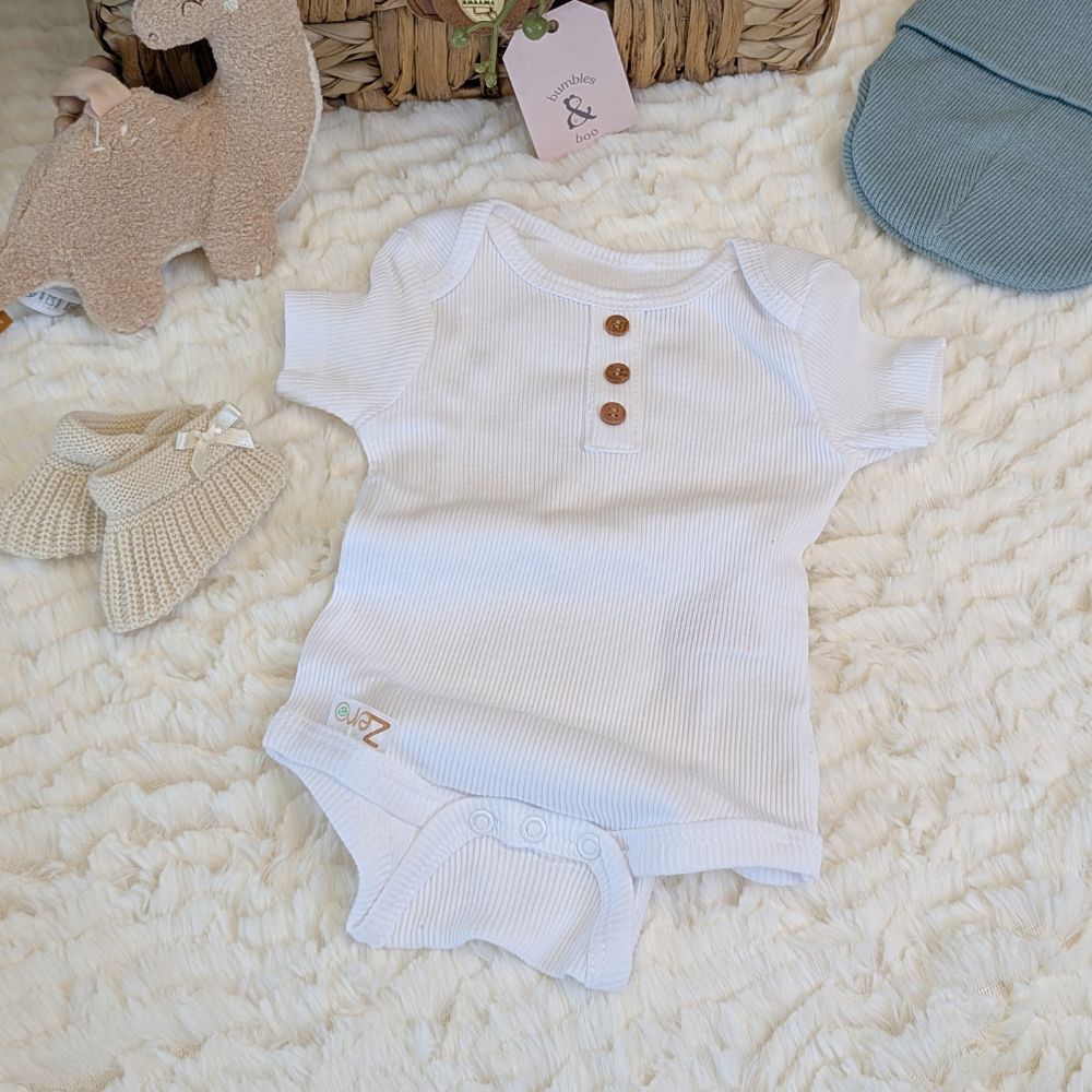 White baby vest with buttons and eco friendly materials.