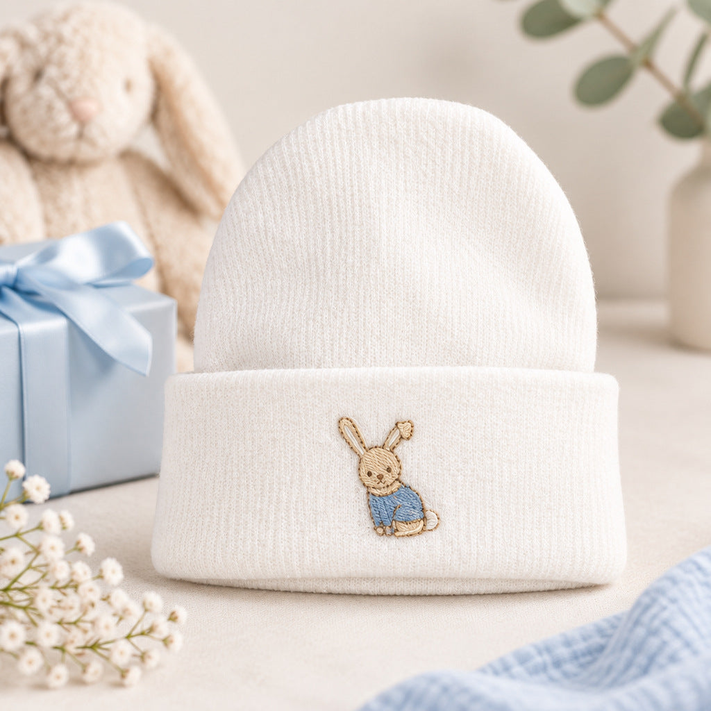 White knitted baby boy beanie hat with a blue embroidered bunny
