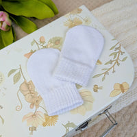 White knit baby mittens.