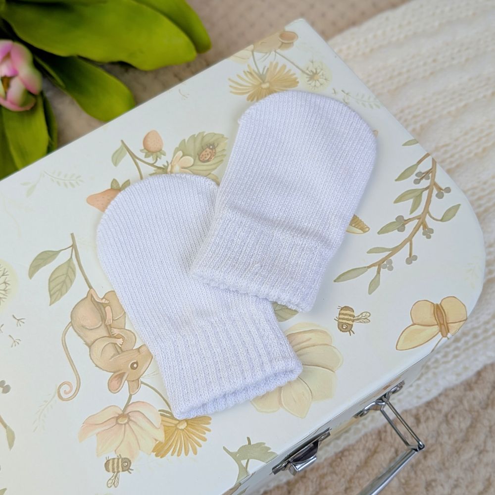 White knit baby mittens.