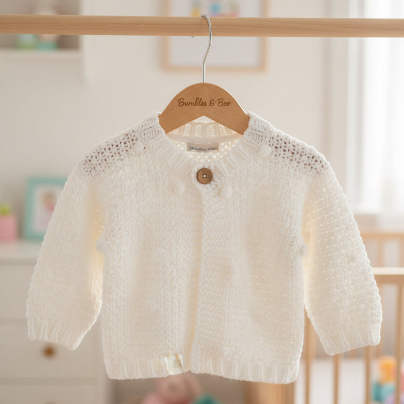 White baby cardigan with chunky knit and pompom detailing
